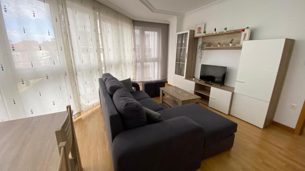 a living room with a couch and a television at A Segunda Ronda in Melide