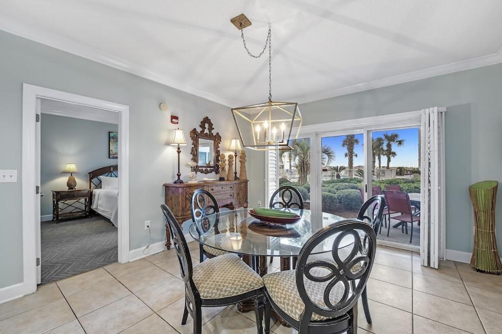a dining room with a glass table and chairs at Palm Beach Resort 15B in Gulf Shores