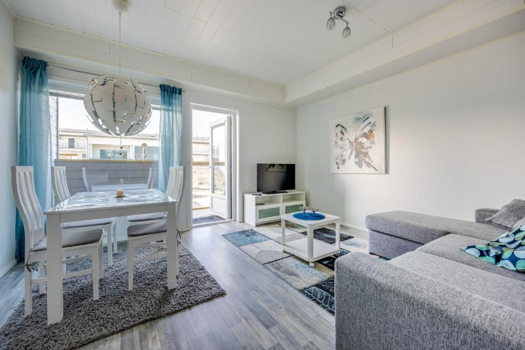 a living room with a table and a couch at Starvillas B 202 Sisältää loppusiivouksen in Kalajoki