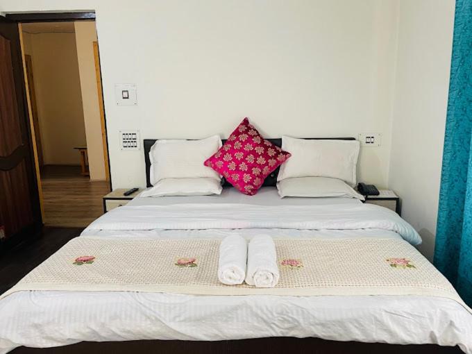 a bed with two pairs of towels on it at Himalayan Haven in Srinagar