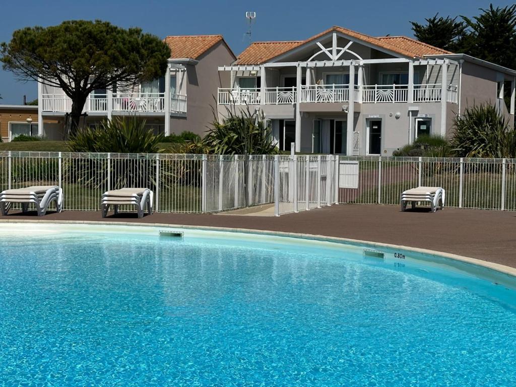 une grande piscine devant une maison dans l'établissement Charmant appartement T2 pour 4 personnes vue mer sables d'olonne, à Saint-Jean-dʼOrbetiers