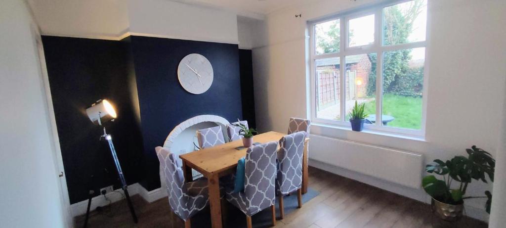 a dining room with a table and chairs and a window at Atrium House in Hazel Grove
