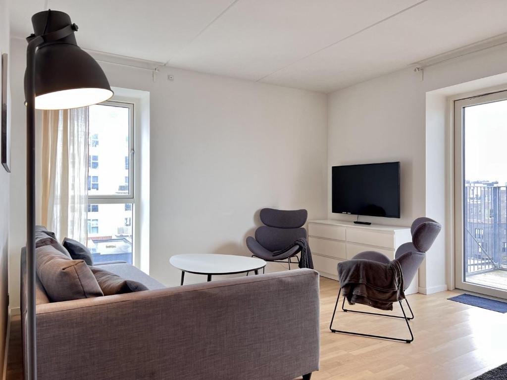 a living room with a couch and a tv at Modern Spacious 3 Bedroom Apartment At Richard Mortensens Vej With Balcony Close To The Royal Arena And Fields in Copenhagen