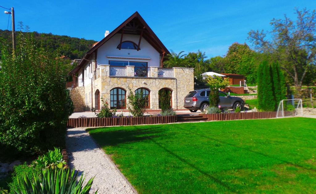 a house with a car parked in front of it at Keith Lakewood Villa in Balatonfüred