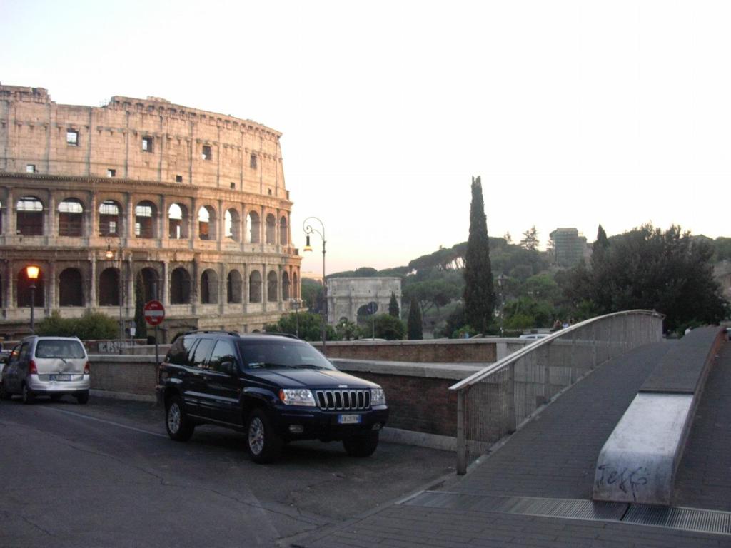 ローマにあるVacanze al Colosseo Polverieraの建物前の駐車場に停められた黒いsuv