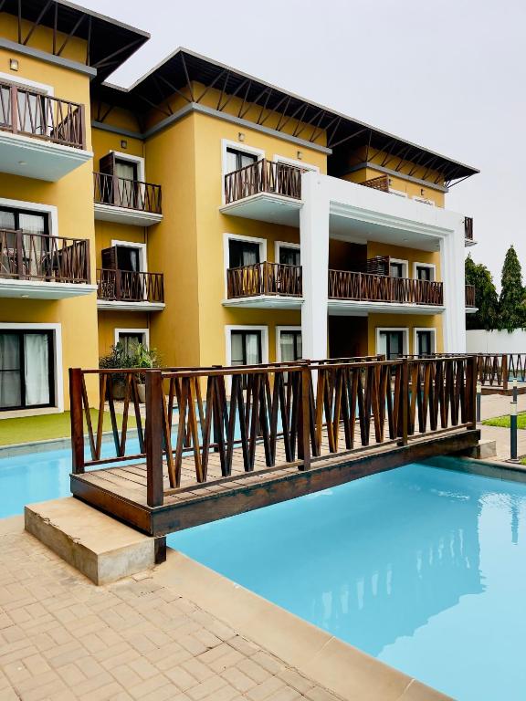 a hotel with a swimming pool in front of a building at Forest view flat in Sere Kunda
