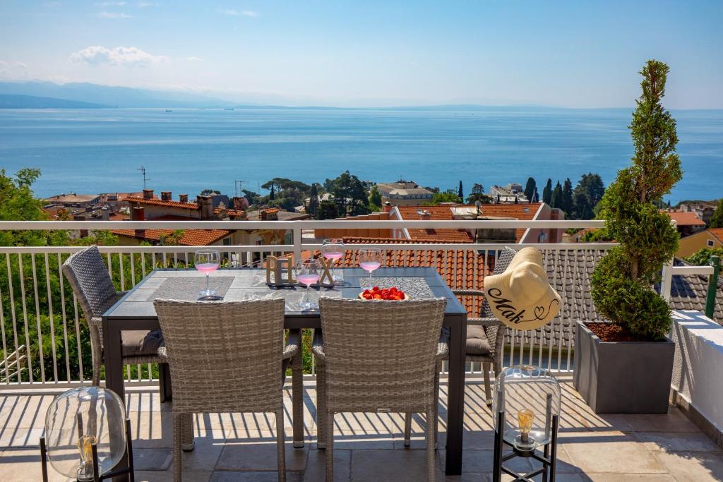 stół i krzesła na balkonie z widokiem na ocean w obiekcie Apartment Mak w mieście Opatija