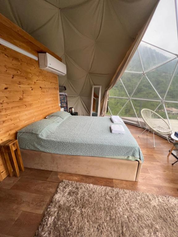 a bedroom with a bed in a tent at Mtirala Glamping in Ch'ak'vist'avi