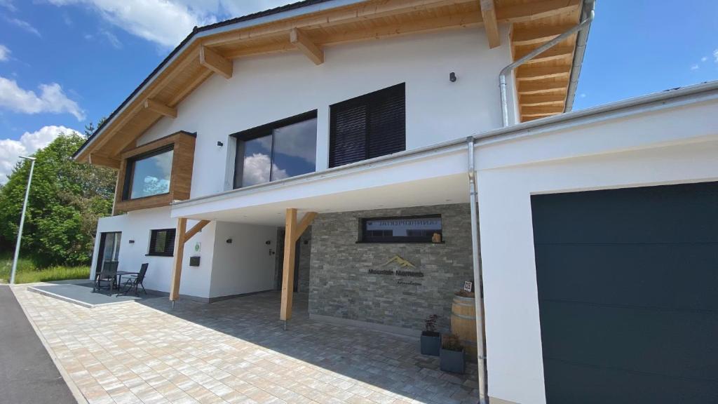 dom z garażem i ceglaną ścianą w obiekcie Mountain Moments Tannheim - Familie Weber w mieście Tannheim
