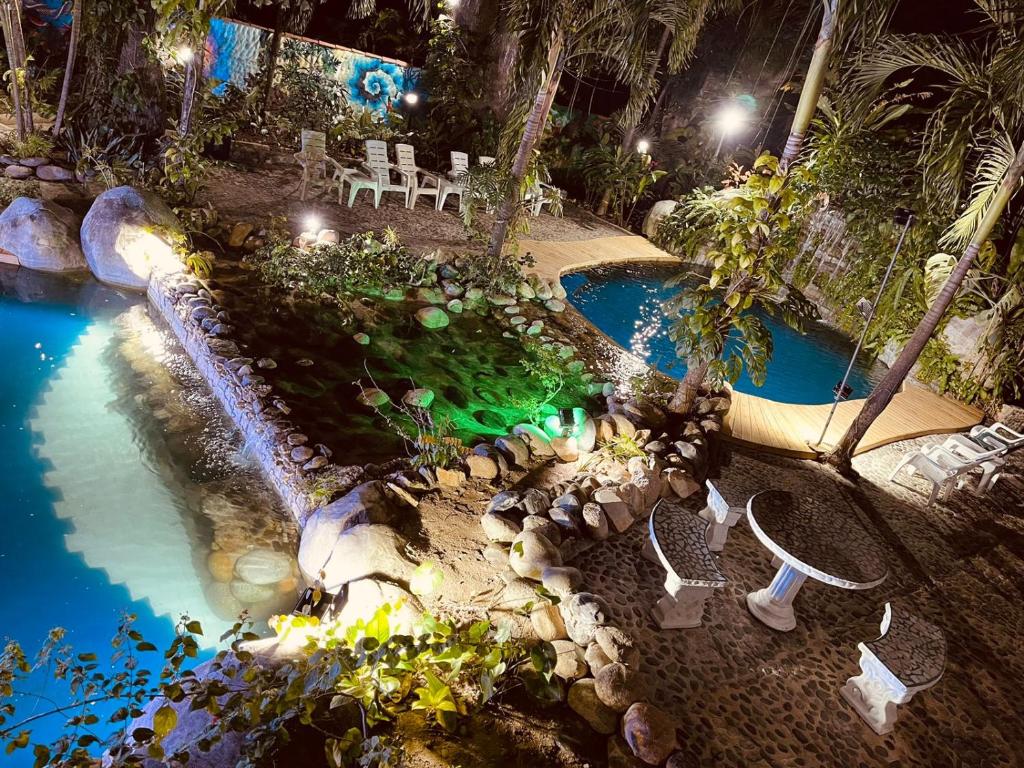 eine Aussicht über einen Pool in einem Resort in der Nacht in der Unterkunft EcoHostal Rio Piedra in El Zaino