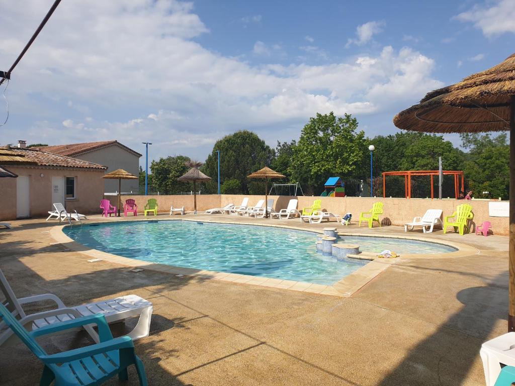 una gran piscina con sillas y un podlvisorvisor en Oasis des Garrigues en Vogüé