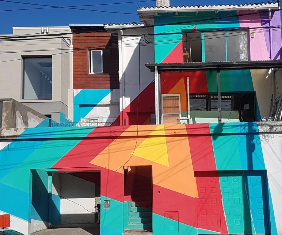 un edificio colorido con un reflejo delante de él en Nina Hostel en San Carlos de Bariloche
