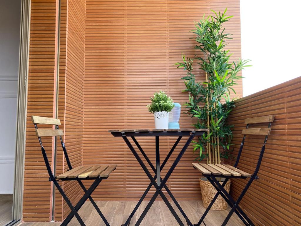 einen Tisch und zwei Stühle vor einer Holzwand in der Unterkunft Magnifique Villa in Beni Mellal