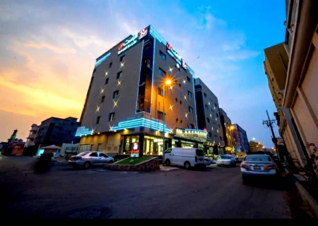 a building with cars parked in a parking lot at Al Rest Inn Hotel in Jazan