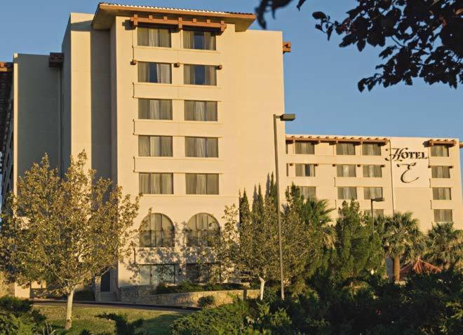 un gran edificio con árboles delante de él en Hotel Encanto de Las Cruces, en Las Cruces