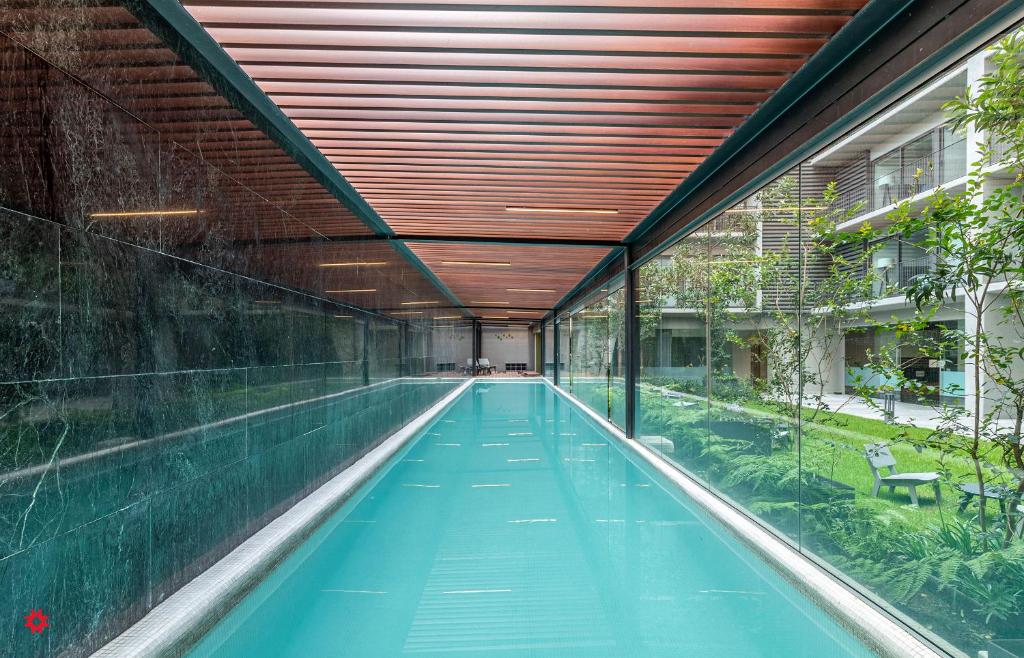 uma piscina interior num edifício com tecto de madeira em Casa Taman by Kukun em Cidade do México