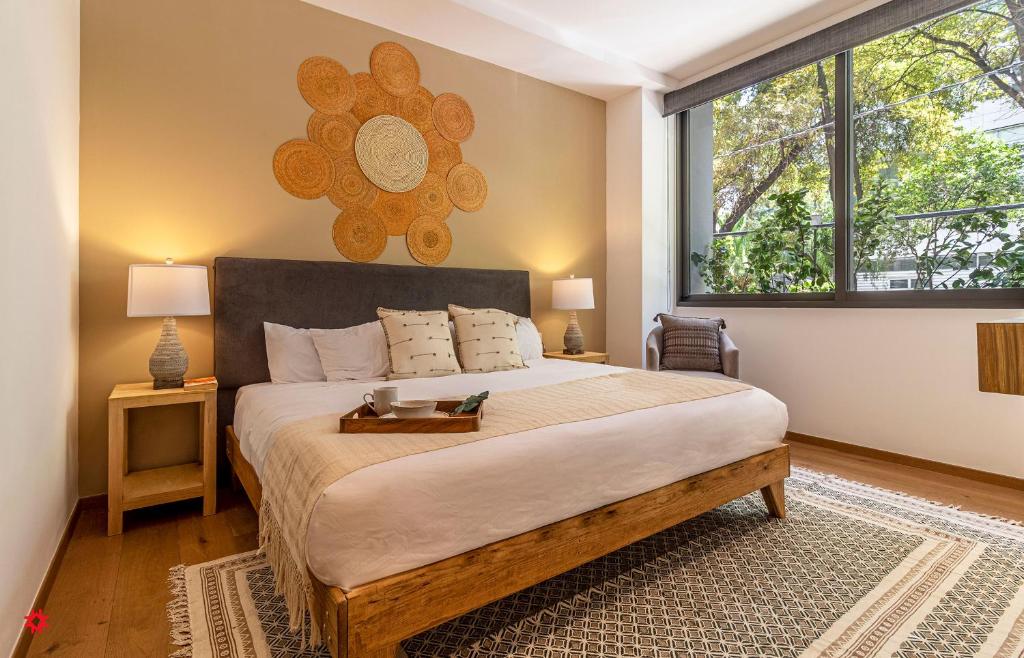 een slaapkamer met een groot bed en een groot raam bij Casa Taman by Kukun in Mexico-Stad