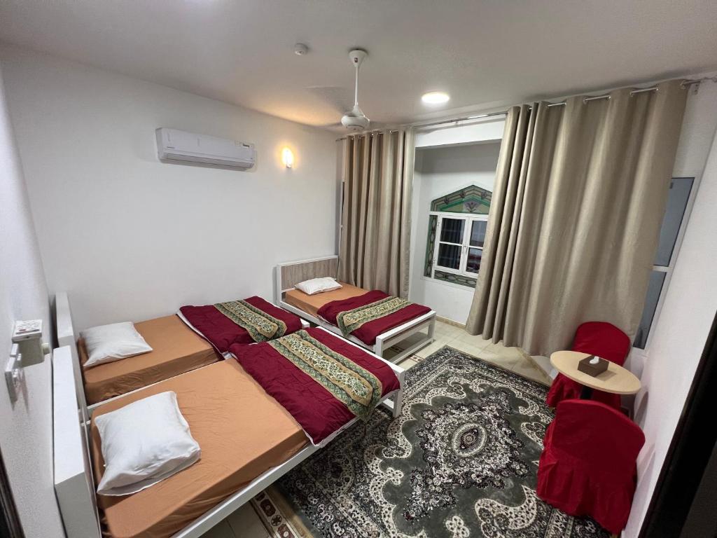 a small room with two beds and a window at ضيافة الأمير The Prince Hospitality in Barka
