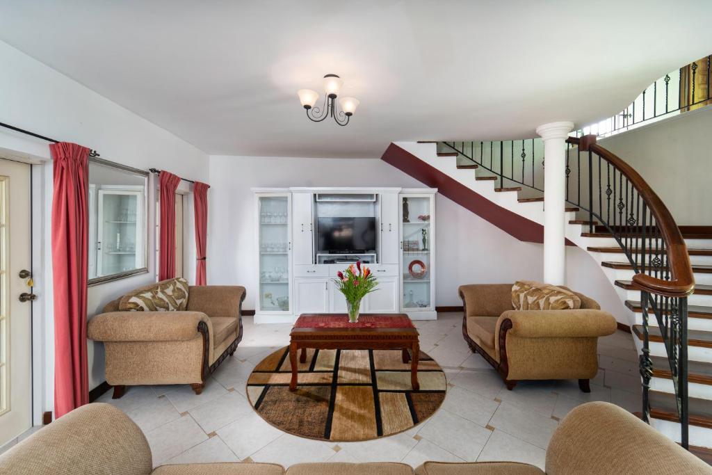 a living room with two couches and a staircase at Ferron House in Saint James