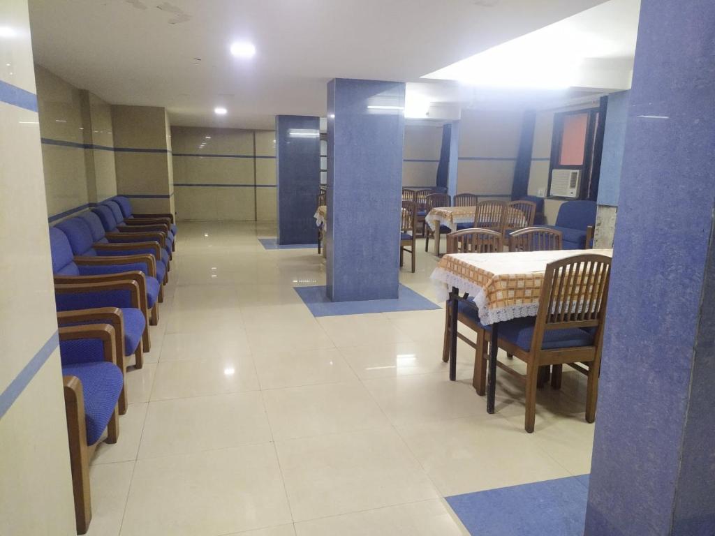 un comedor con mesas, sillas y sillas azules en Hotel Ashok Tuliip Bhiwandi, en Thane