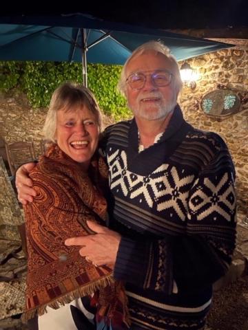 un homme et une femme âgés debout sous un parapluie dans l'établissement Les Petits Vingnes, à Édon