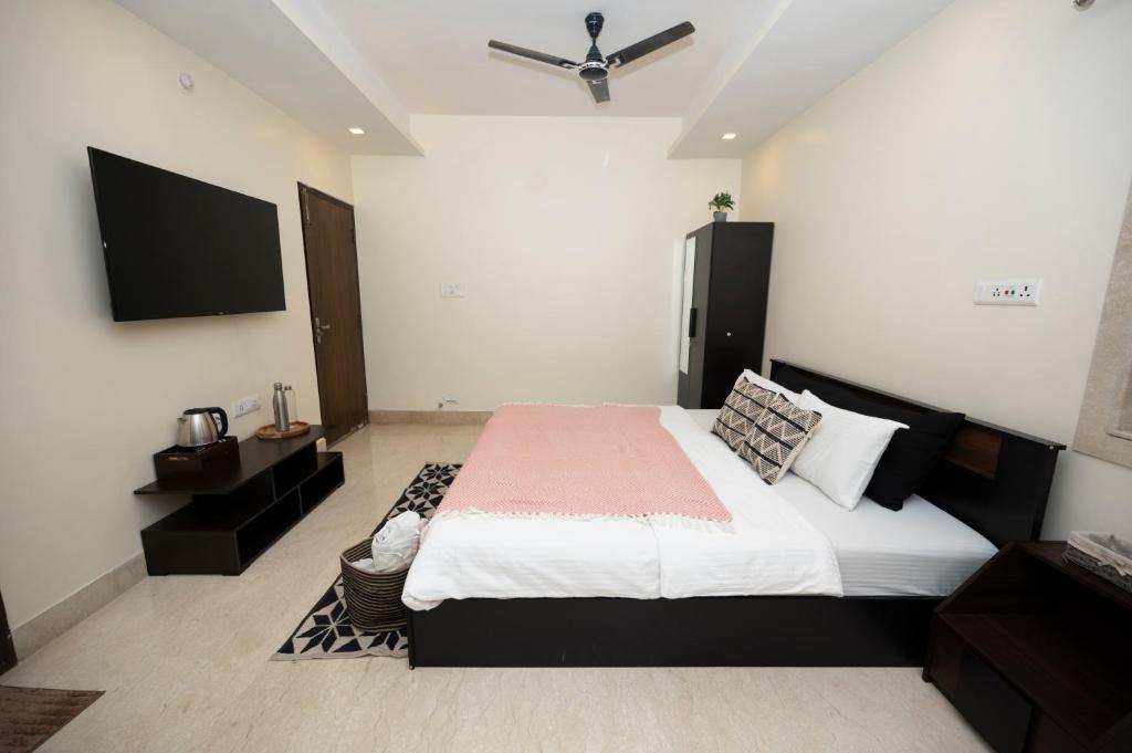 a bedroom with a large bed and a flat screen tv at Lakeside Suites in Kolkata