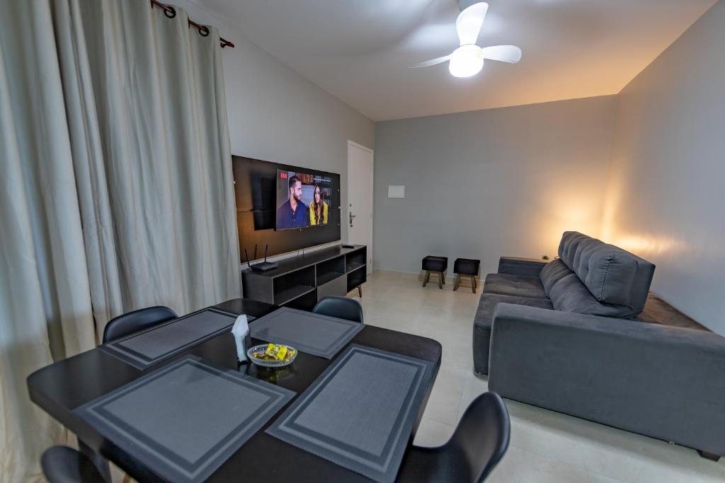 - un salon avec un canapé et une table dans l'établissement Lindo apartamento 2 quartos com wifi, à Rio das Ostras