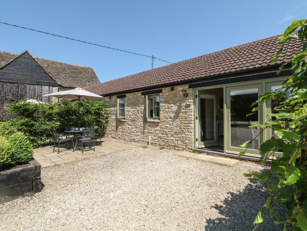 an external view of a cottage with a patio at Saddlebacks Barn in Burford