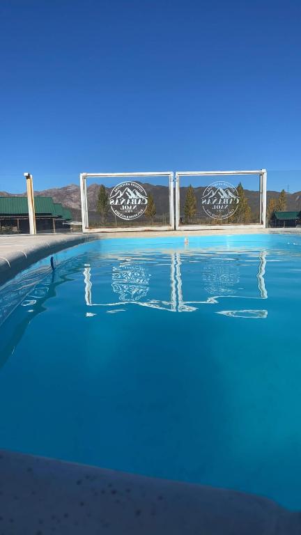 a swimming pool with blue water in front of a building at Naol village in Uspallata