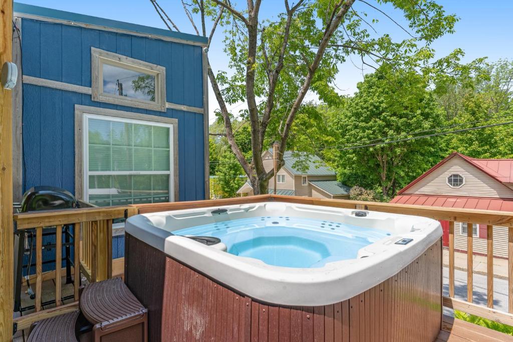a hot tub on the deck of a house at Tiny Homes on Pleasant in Ludlow