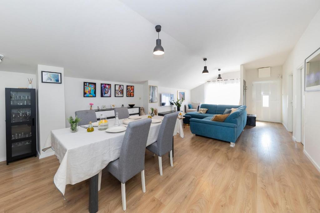 uma sala de estar com uma mesa e um sofá azul em Sunset Apartment em Zadar