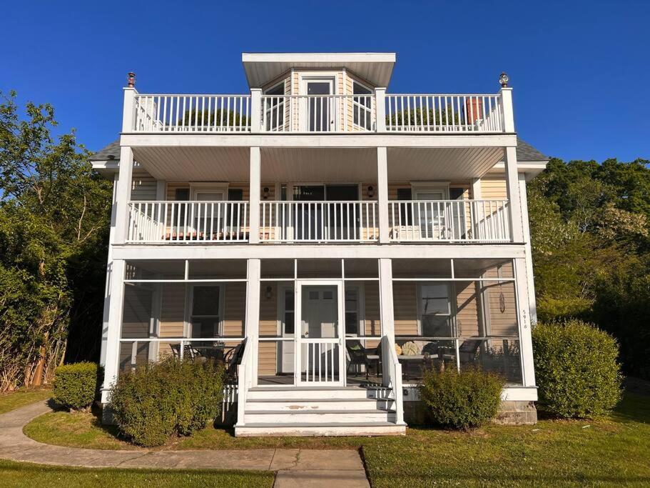 a large white house with a porch and balcony at The Happy Place in Tilghman Island
