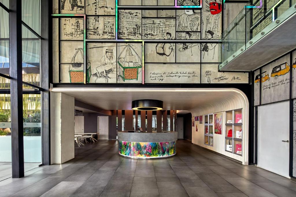 a lobby of a building with drawings on the wall at Aloft Jakarta Wahid Hasyim in Jakarta