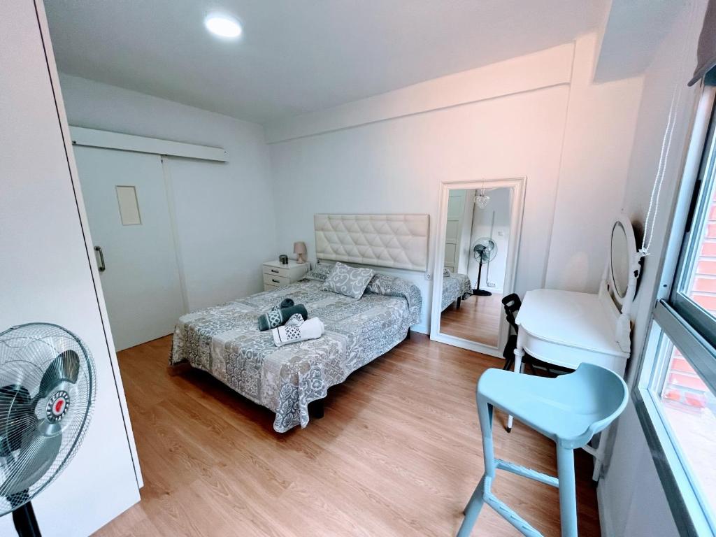 Valencia Apartament Encantador في فالنسيا: غرفة نوم صغيرة بها سرير وكرسي