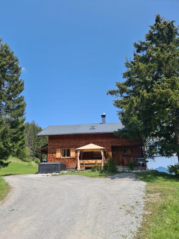 una casa con una entrada de grava delante de ella en Burtscha Lodge im Sommer inklusive der Gästekarte Premium en Bürserberg