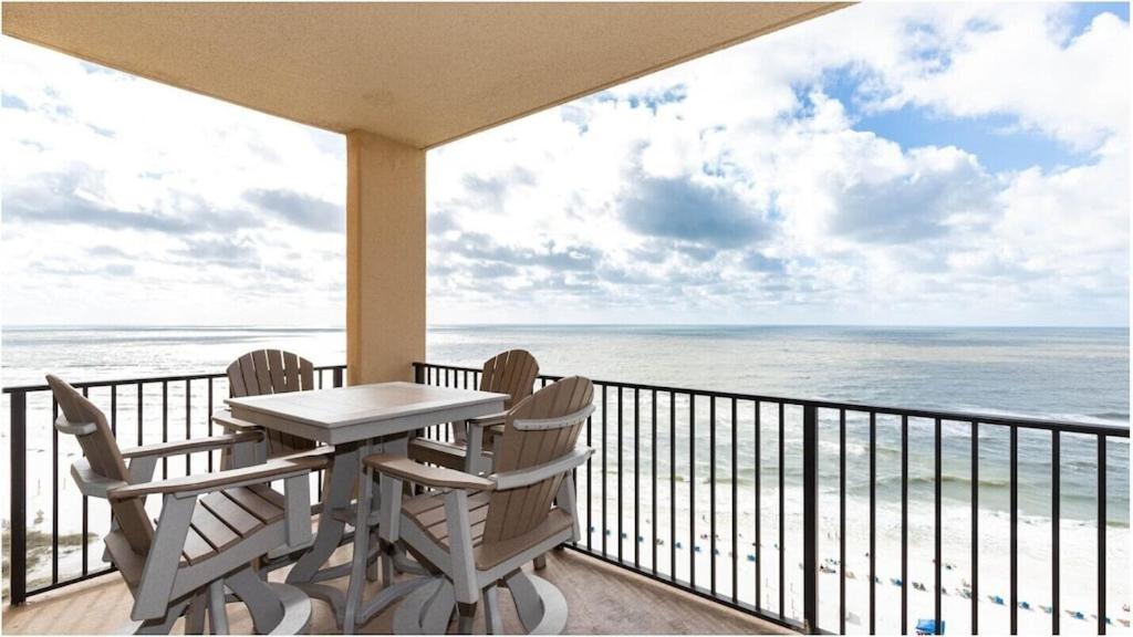 a balcony with a table and chairs and the ocean at Phoenix 5 Unit 1504 in Orange Beach