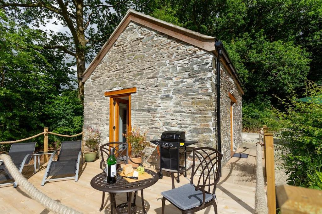 a small stone house with a table and chairs at The Dairy in Tavistock