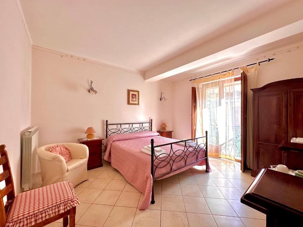 a bedroom with a bed and a chair and a window at Il ritrovo delle Volpi in Agerola