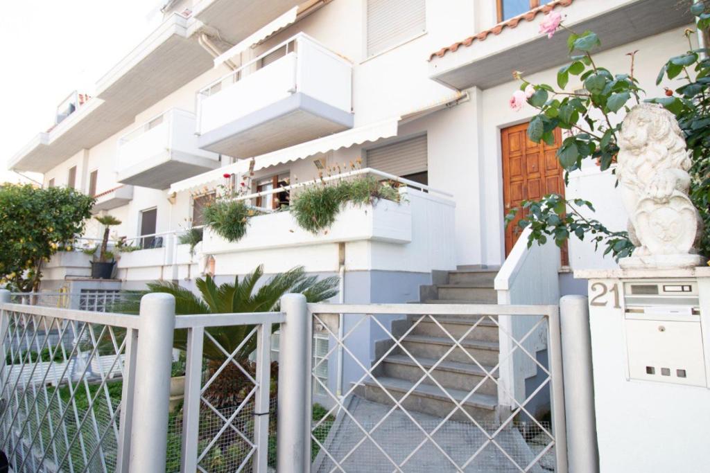 a white house with stairs and a fence at Appartamento del sole in San Benedetto del Tronto