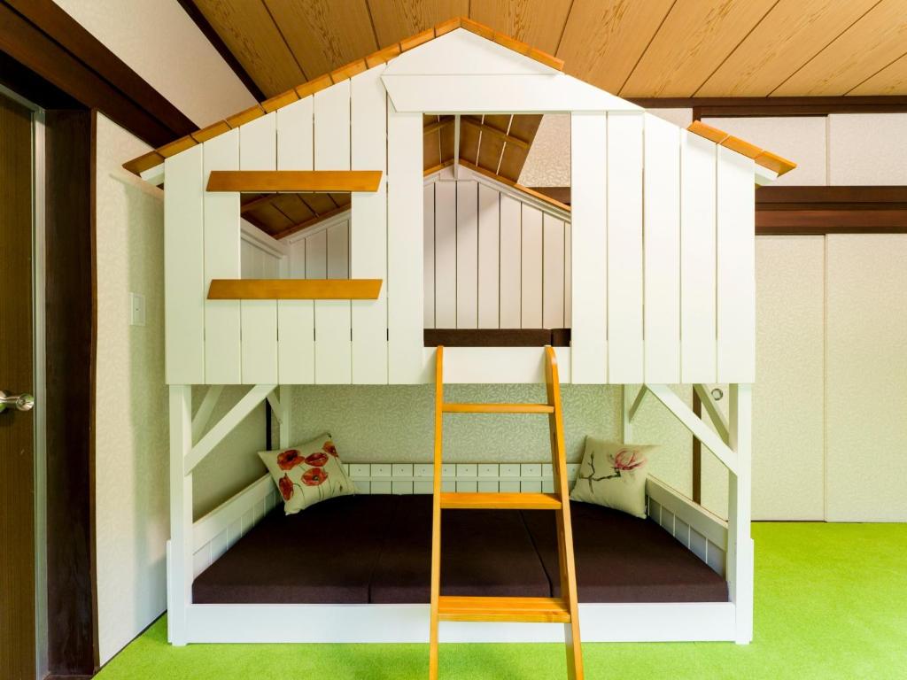 ein Püppchen-Etagenbett mit einer Leiter in einem Zimmer in der Unterkunft Yuraku Izu-Oshima - Vacation STAY 44742v in Oshima