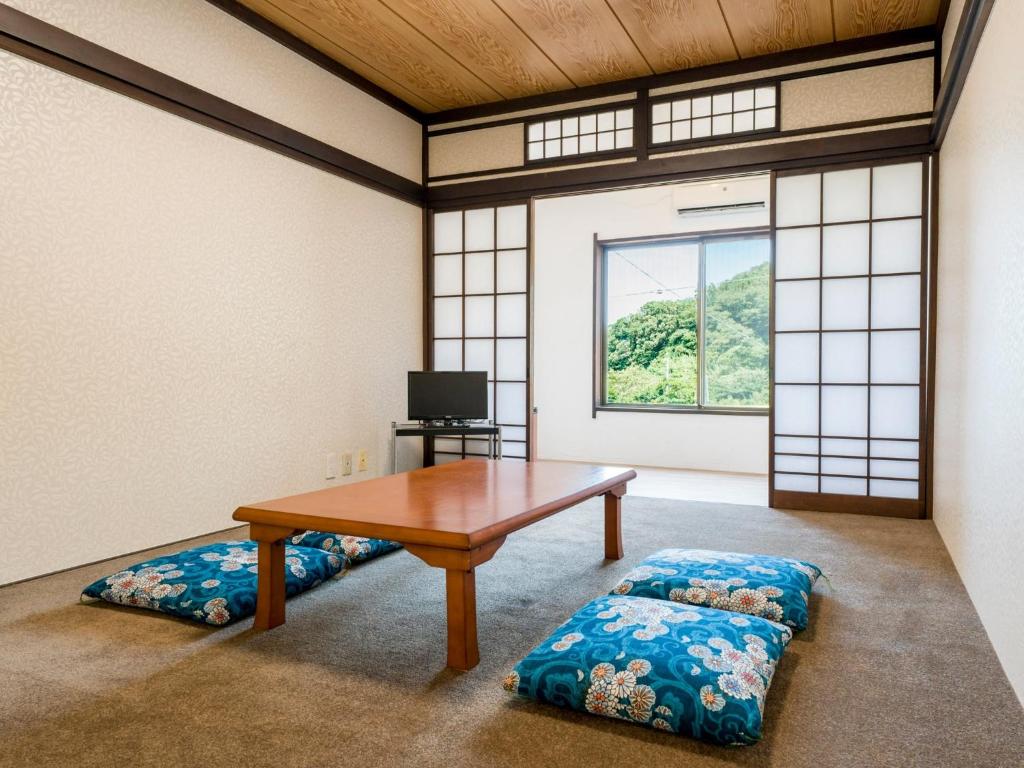Habitación con mesa, banco y ventana en Yuraku Izu-Oshima - Vacation STAY 44711v, en Oshima