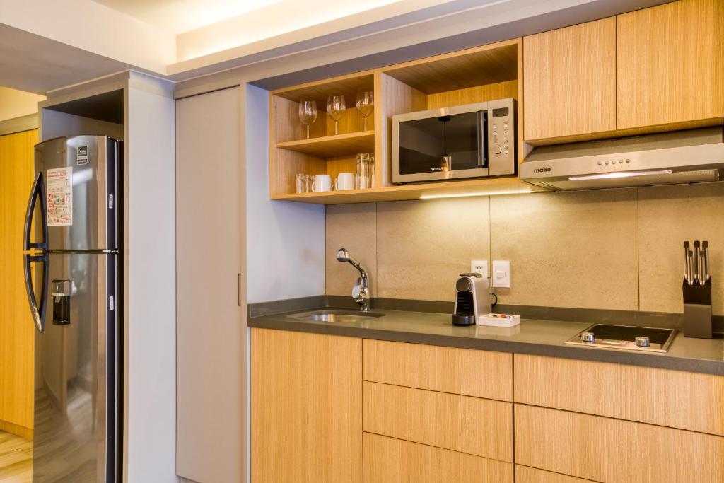 A built-in kitchenette with a two-burner cooktop, microwave, refrigerator and coffee station.