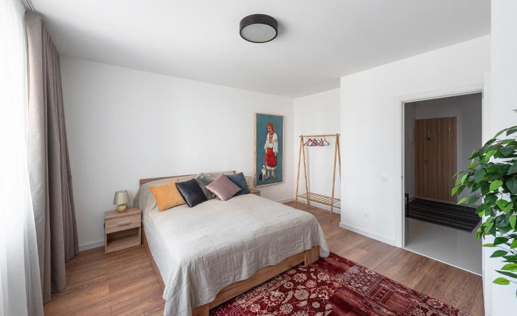 - une chambre blanche avec un lit et un tapis dans l'établissement Luxury Apartment Slava Ukraini, à Ivano-Frankivsk
