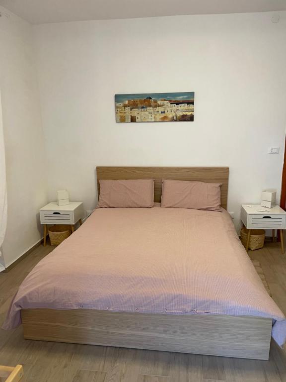 una camera da letto con un grande letto con due tavoli di La casa di Michela a Torino di Sangro