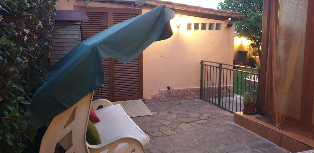 a backyard with a blue umbrella and a bench at Suite Felix in Fiumicino