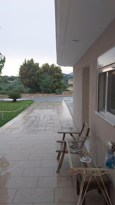 a patio with two chairs and a table and a street at studio-02 in Metókhi