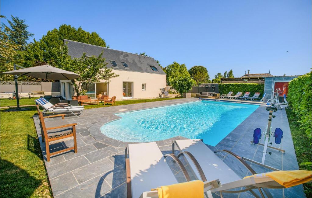 una piscina con sedie e un ombrellone di 3 Bedroom Amazing Home In Fondettes a Fondettes