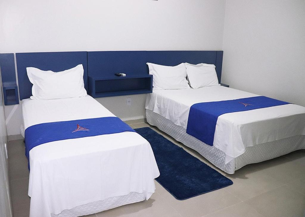 two beds in a room with blue and white at PARIS HOTEL in Barreiras