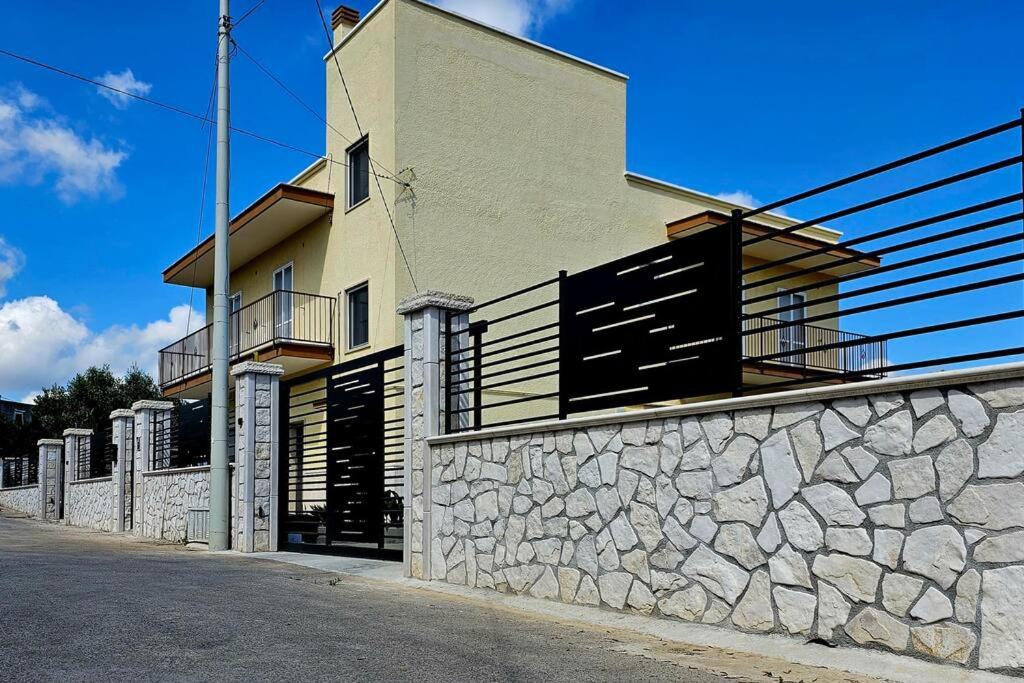 a building with a stone wall next to a street at Casa vacanze Moretto in Ceglie Messapica