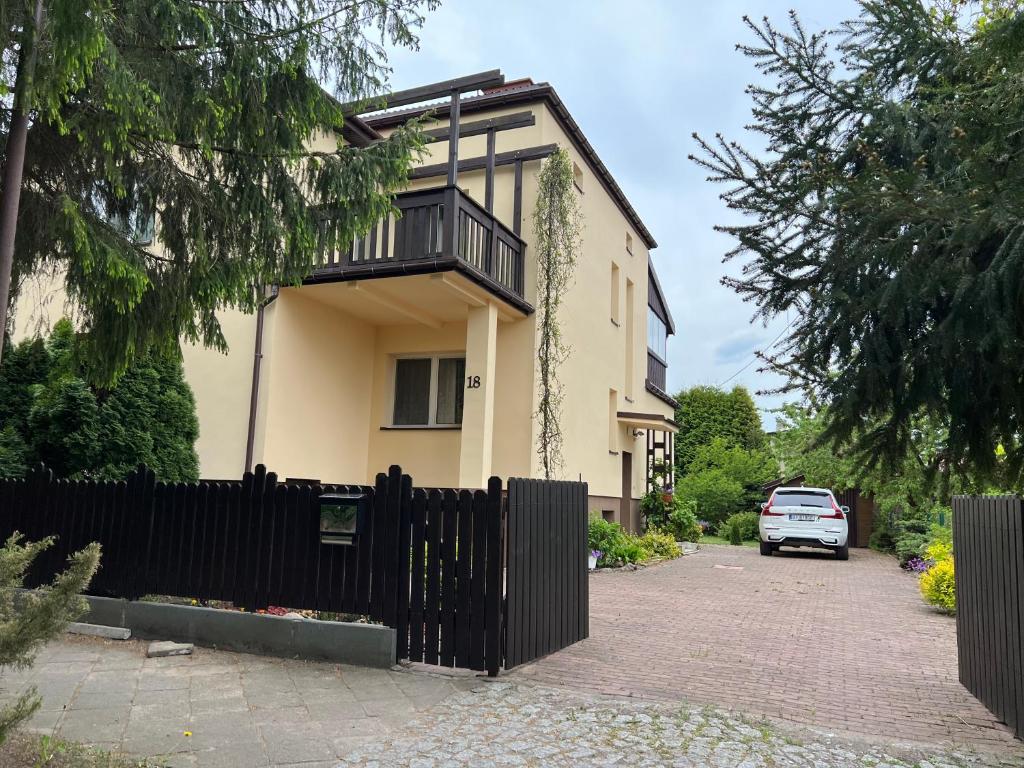 una casa con una valla negra delante de ella en AGA en Augustów